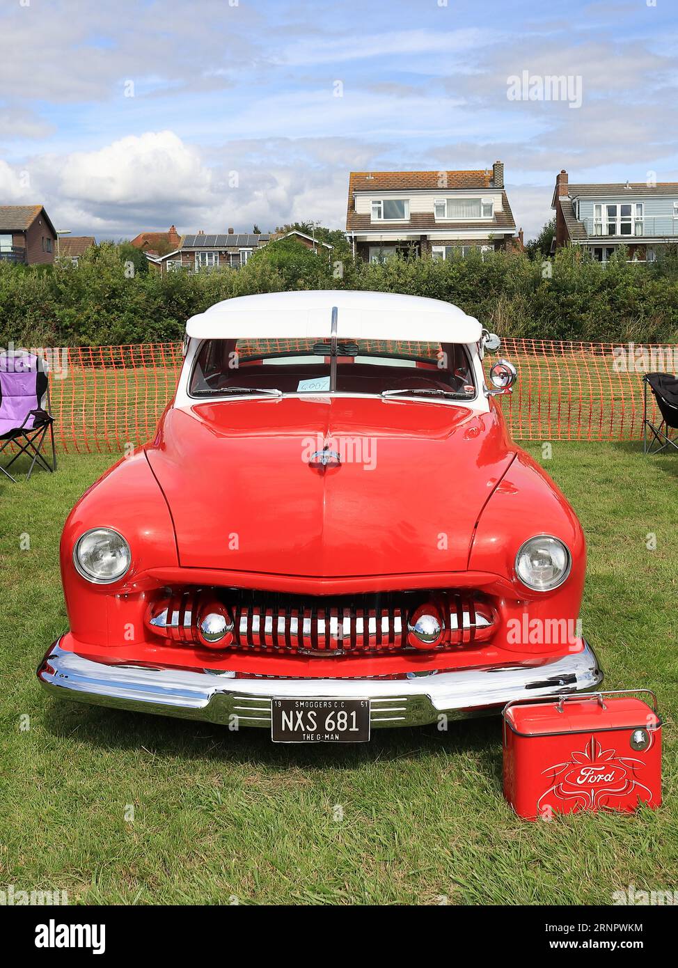 1951 red Ford Mercury Coupe, on display, front view. The Gosport Car Rally is organised by the local Rotary Club and takes place at Stokes Bay on the August bank holiday Monday. This year's event, providing a cheap family day out, was the seventieth and hosted vintage cars and motorbikes, a petting farm, stalls, refreshments and an arena which provided various forms of entertainment. Stock Photo