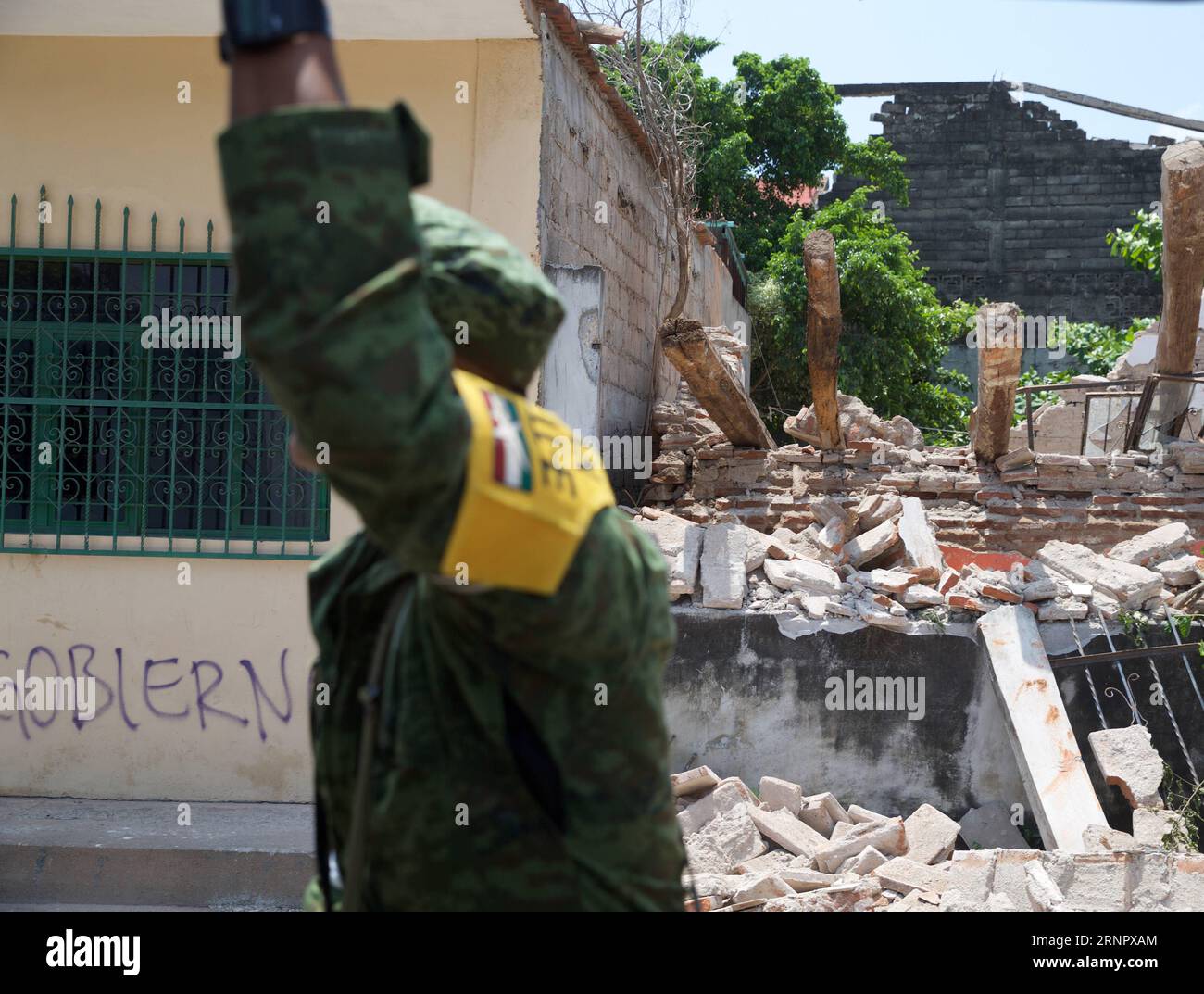 (170910) -- JUCHITAN (MEXICO), Sept. 10, 2017 -- A soldier walks past a damaged house after an earthquake hit in Juchitan, Oaxaca state, Mexico, Sept. 9, 2017. A powerful earthquake measuring 8.2 on the Richter scale struck off Mexico s southern coast late Thursday night, killing 90 people. ) MEXICO-OAXACA-JUCHITAN-EARTHQUAKE DanxHang PUBLICATIONxNOTxINxCHN Stock Photo