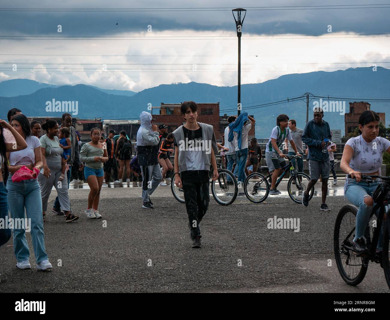 Medellín, Medellin, Antioquia, Colombia - May 28 2023: Young Colombian Walking in a Public Park with many Young People Around him on Bicycles or Walki Stock Photo