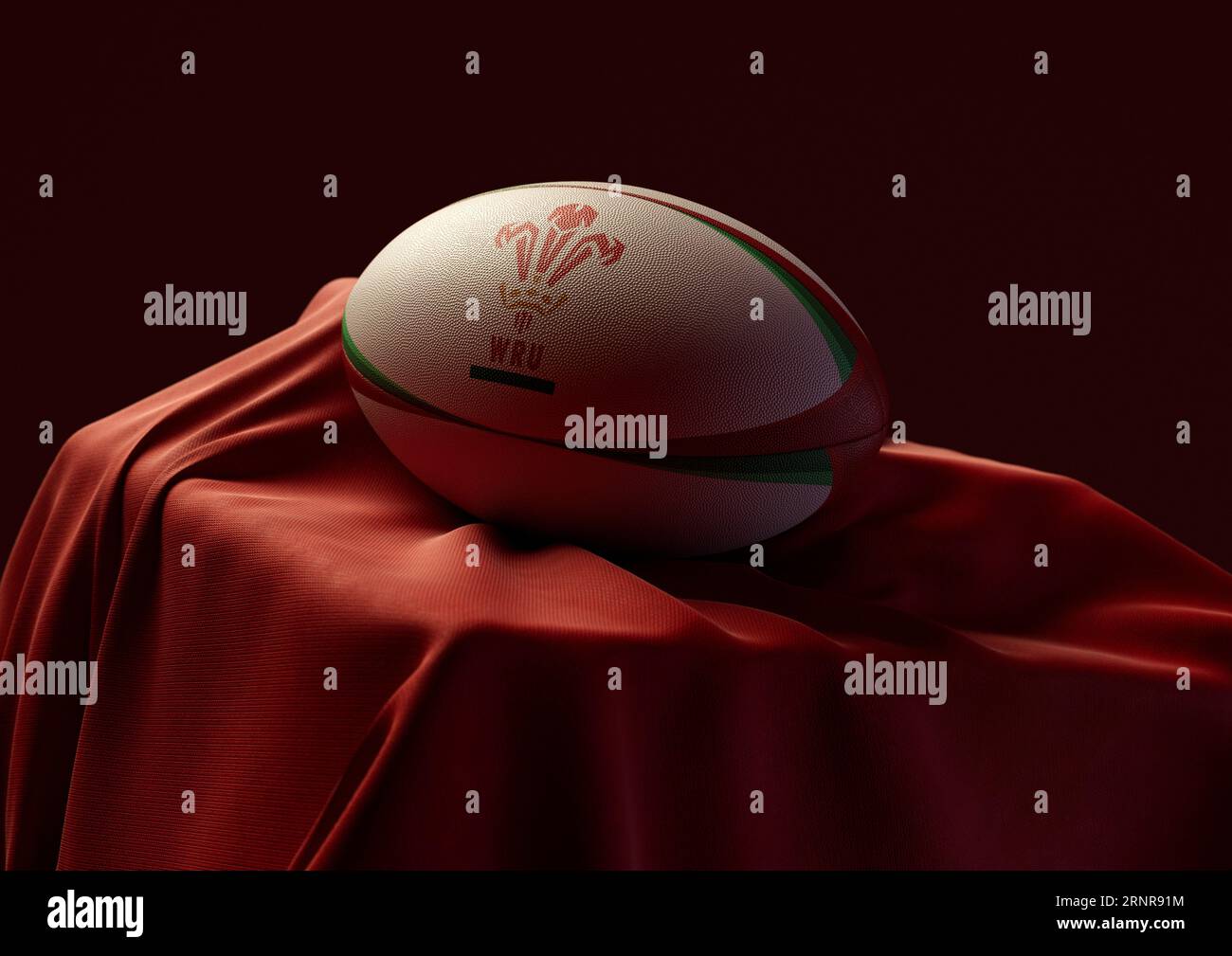 September 2, 2023 - Bristol, United Kingdom: A 3D render of a rugby ball imprinted with the Wales rugby logo resting on a draped red fabric Stock Photo