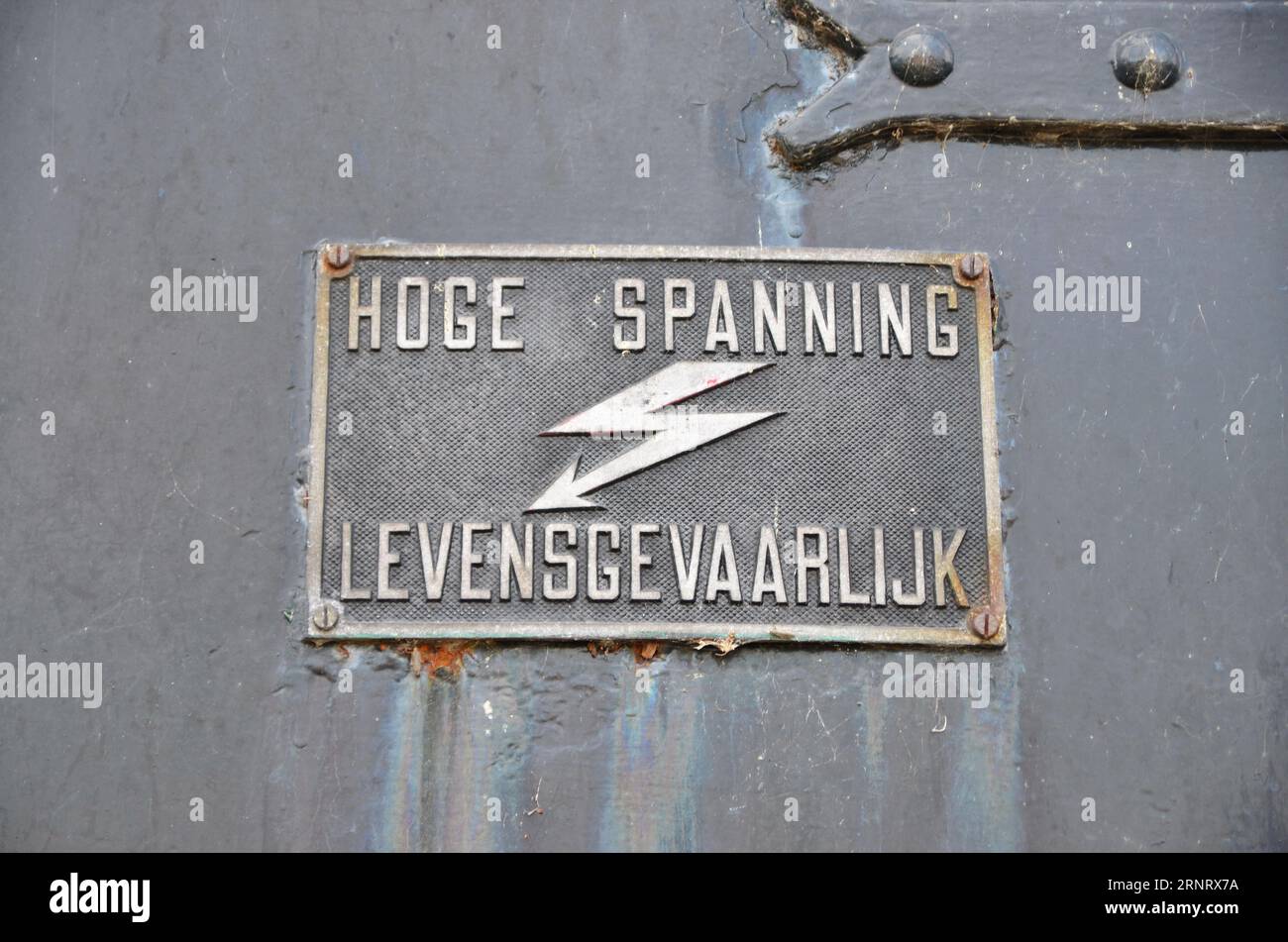 The photo is a Dutch warning sign for high voltage. The color play on the surface reflects the traces of the past. Stock Photo
