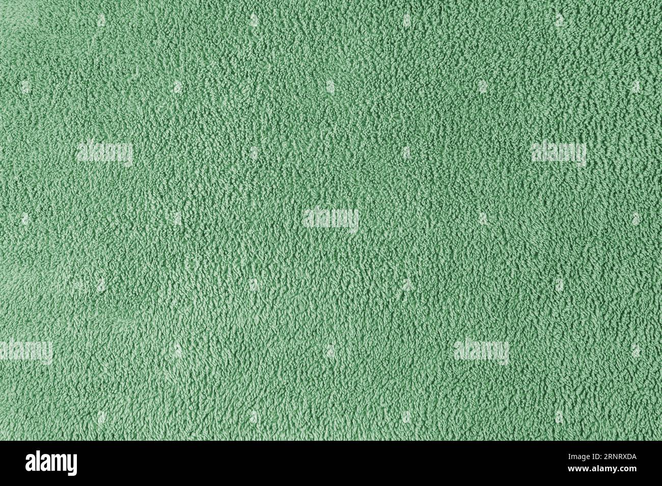 Terry cloth, green towel texture background. Soft fluffy textile bath or beach towel material. Top view, close up. Stock Photo