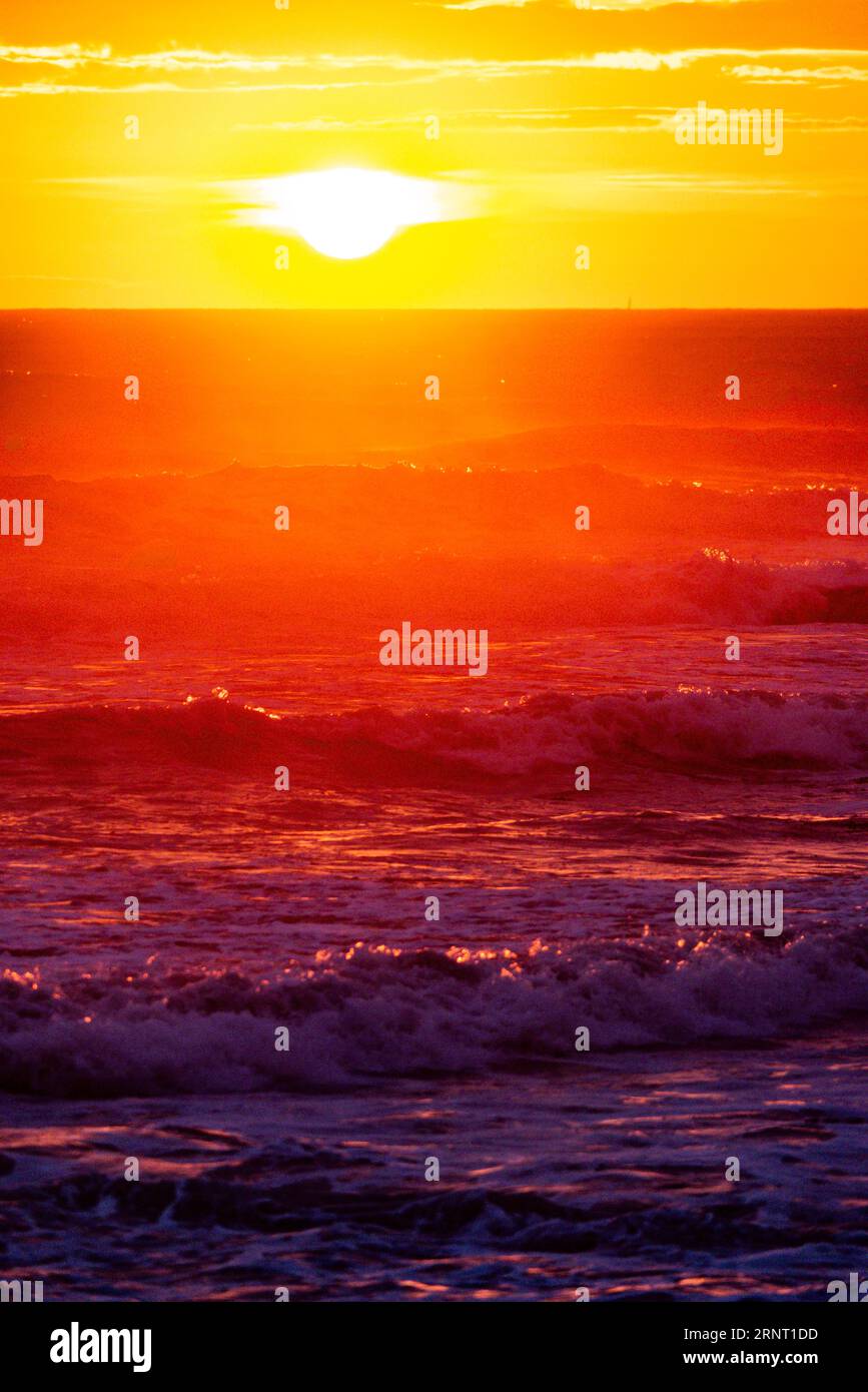 Sunset with high waves at the sea with psychedelic colours, Portbail, English Channel, Cotentin, Manche, Normandy, France Stock Photo