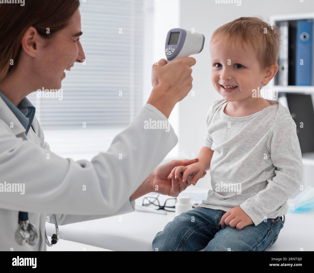 Doctor checking baby s temperature Stock Photo Alamy