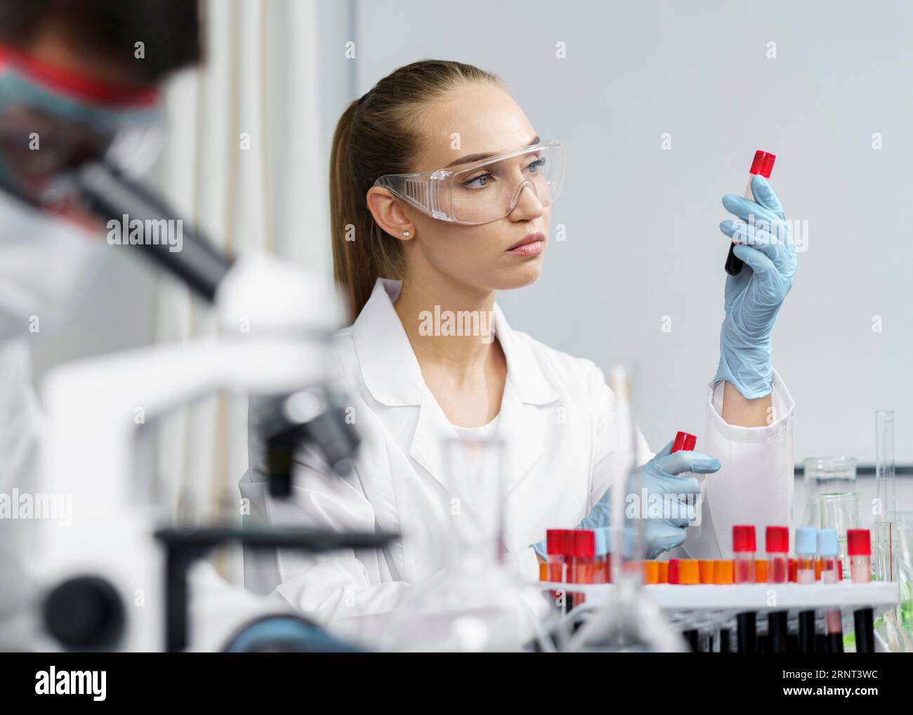 Female researcher laboratory with test tubes safety glasses male ...