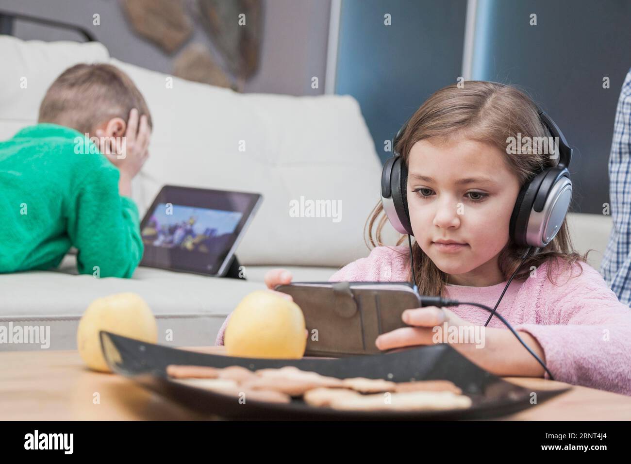 Kids using technologies living room Stock Photo