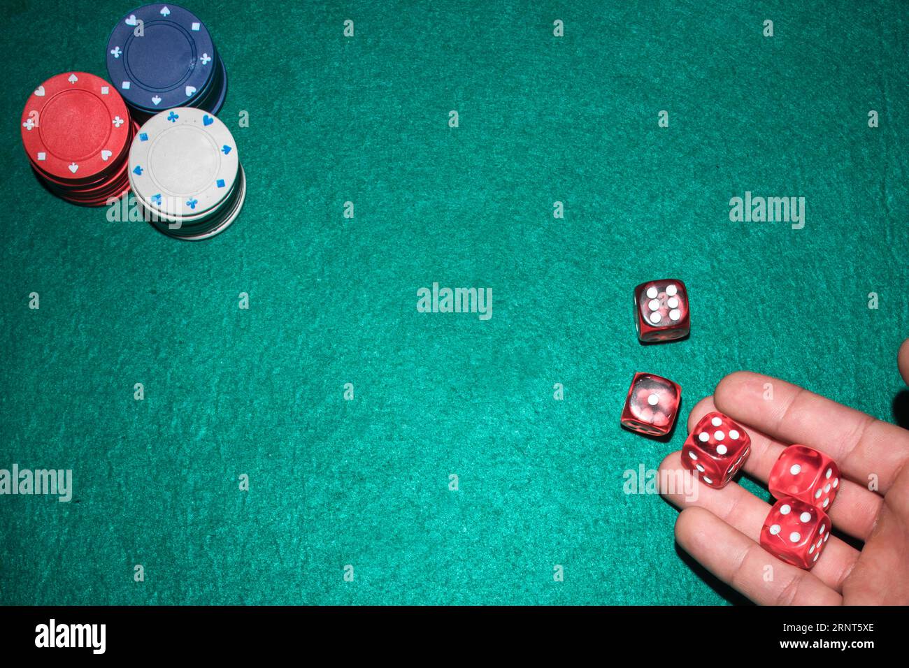 Poker player s hand throwing red dices poker table Stock Photo