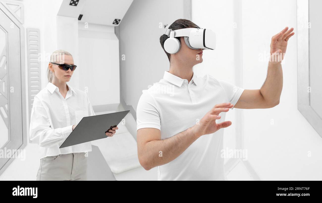Young man with virtual reality simulator woman testing Stock Photo
