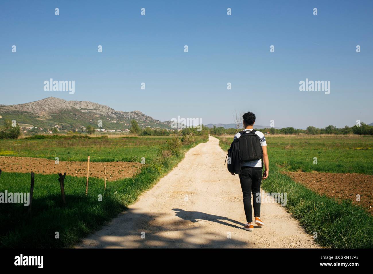 Young man walking nature trail with carrying backpack Stock Photo - Alamy