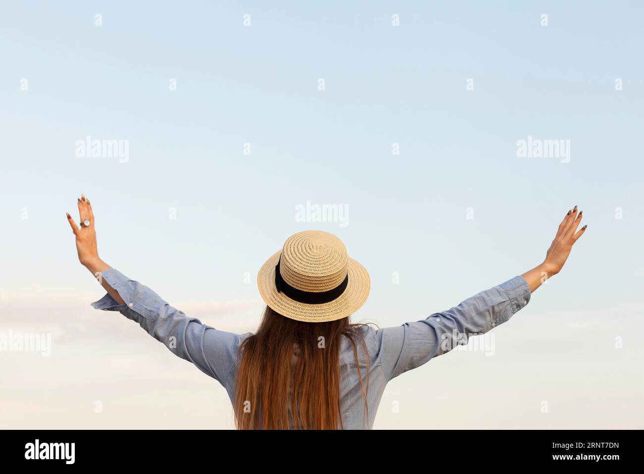 Back view woman with posing outdoors with arms open Stock Photo