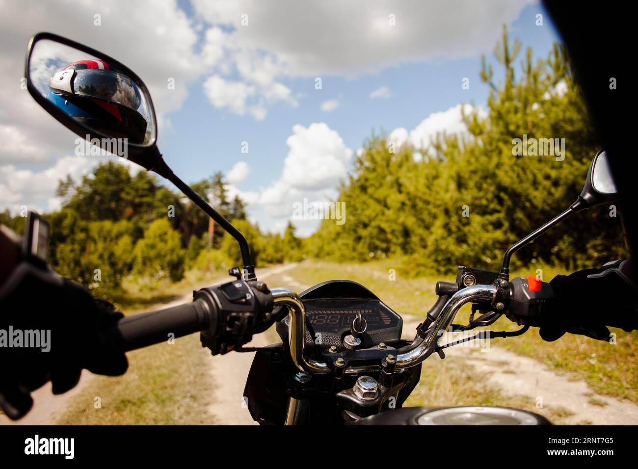 Biker riding motorbike dirt road Stock Photo - Alamy