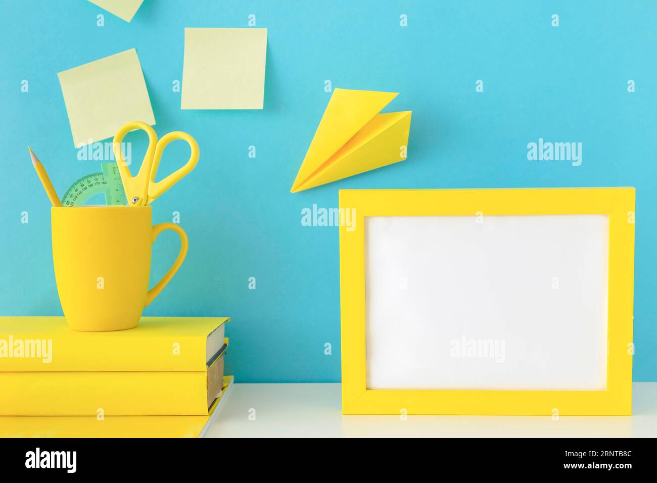 Stylish workplace with yellow frame paper plane Stock Photo