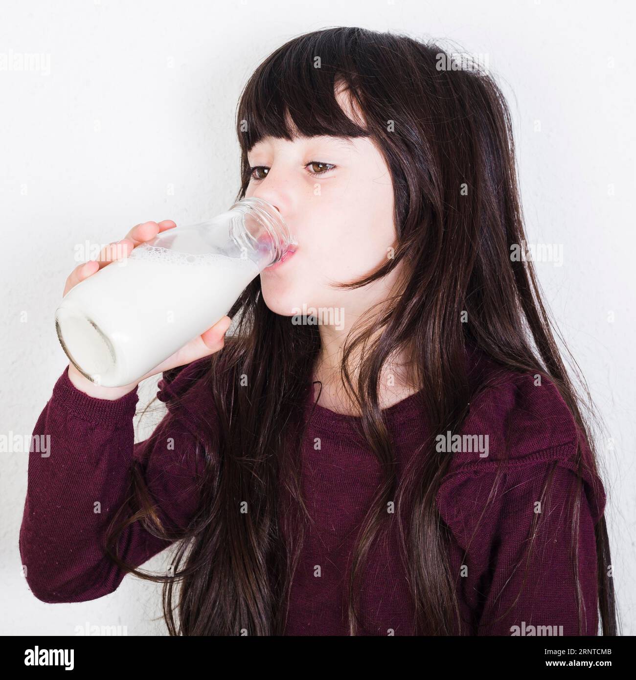 Close up cute girl drinking milk from bottle Stock Photo