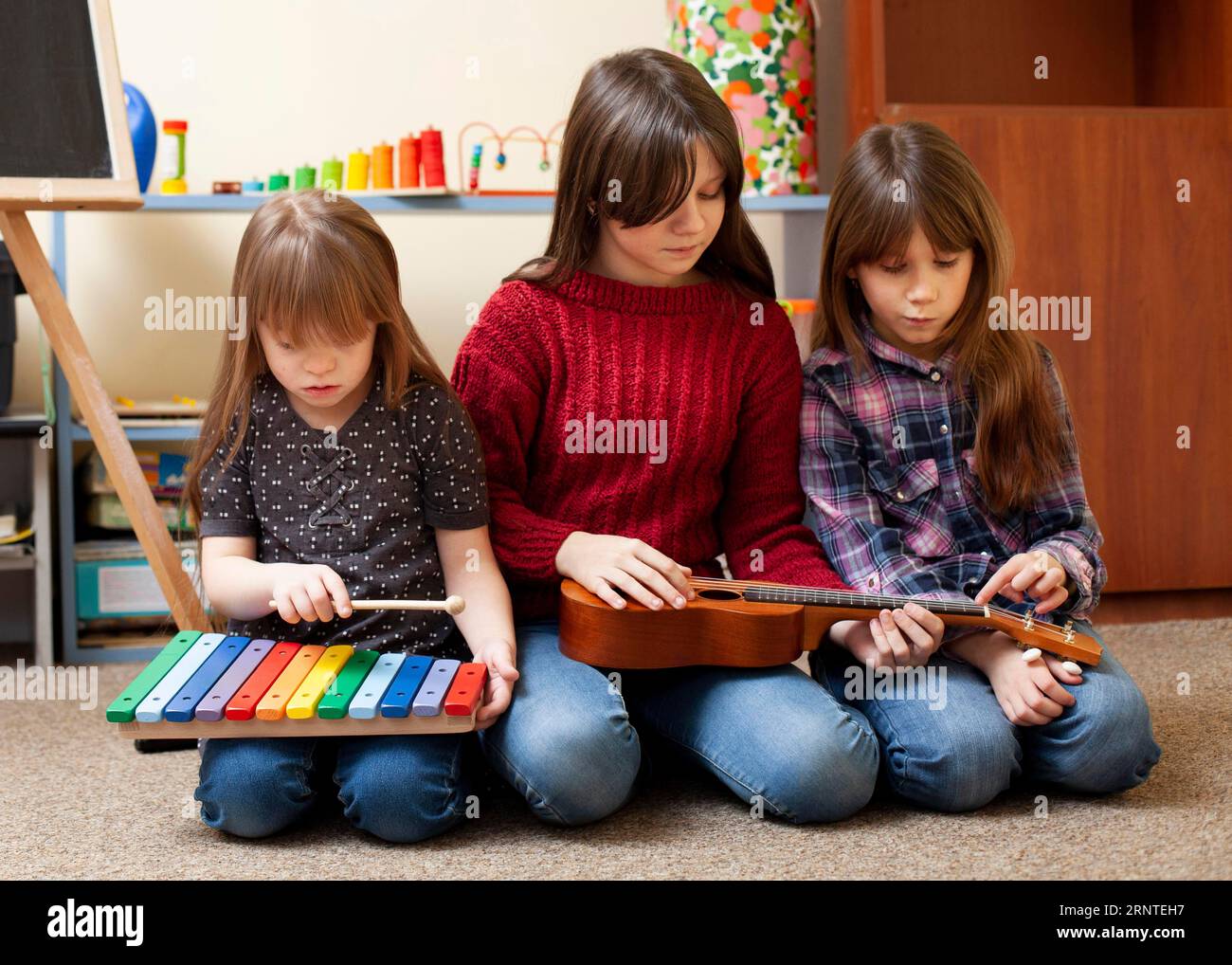Kids playing together with guitar xylophone Stock Photo Alamy