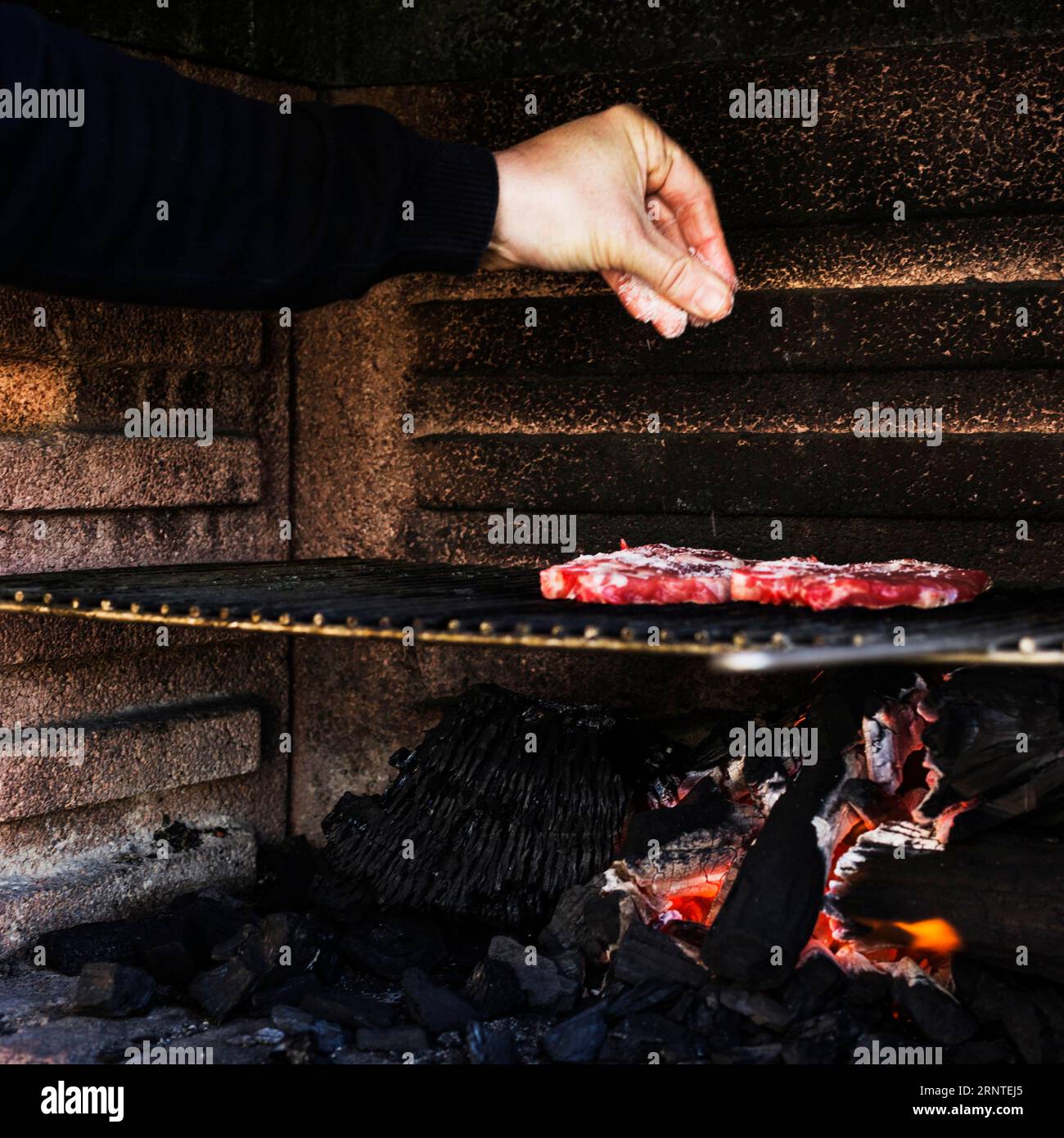 Human hand seasoning meat barbecue grill Stock Photo