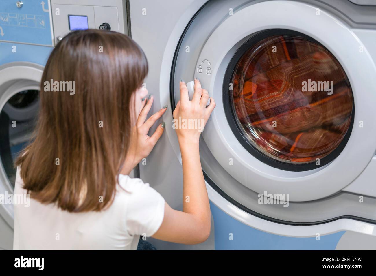 Lady closing washing machine door Stock Photo