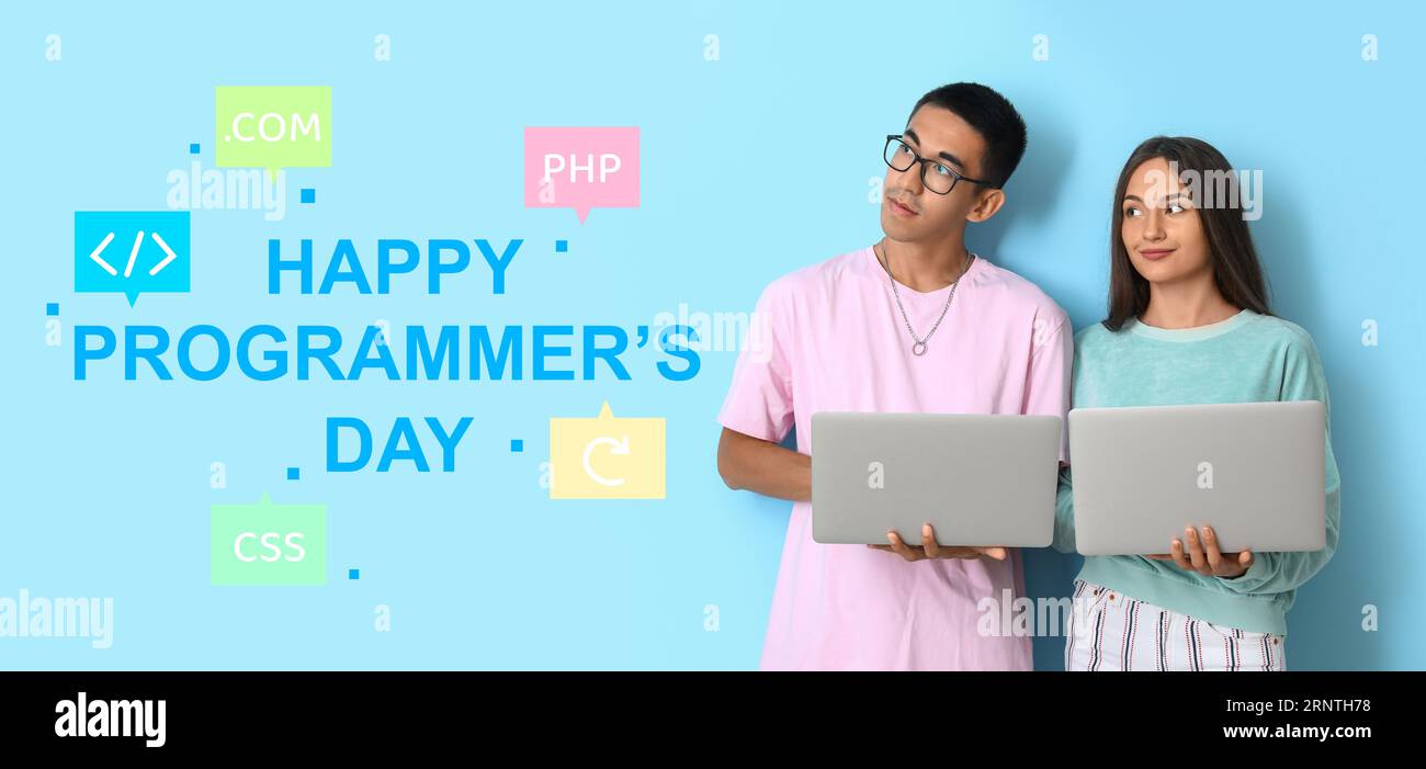 Young couple with laptops and text HAPPY PROGRAMMER'S DAY on light blue background Stock Photo