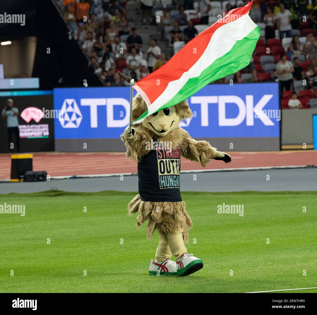 Youhuu the mascot waves the flag of Hungary during the closing ceremony
