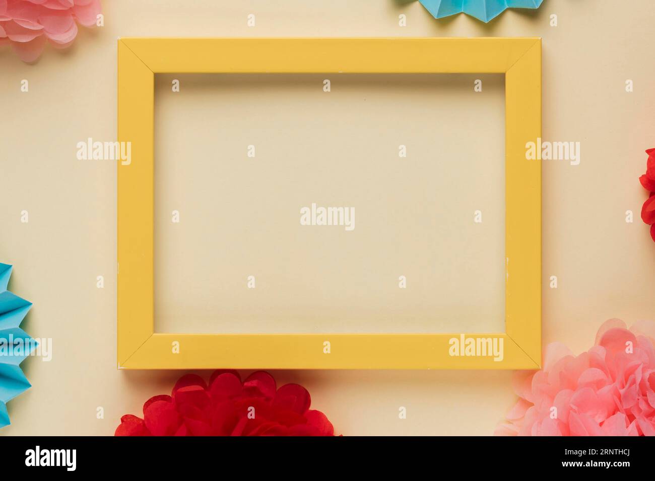 Yellow wooden border picture frame with decorated origami flowers Stock Photo
