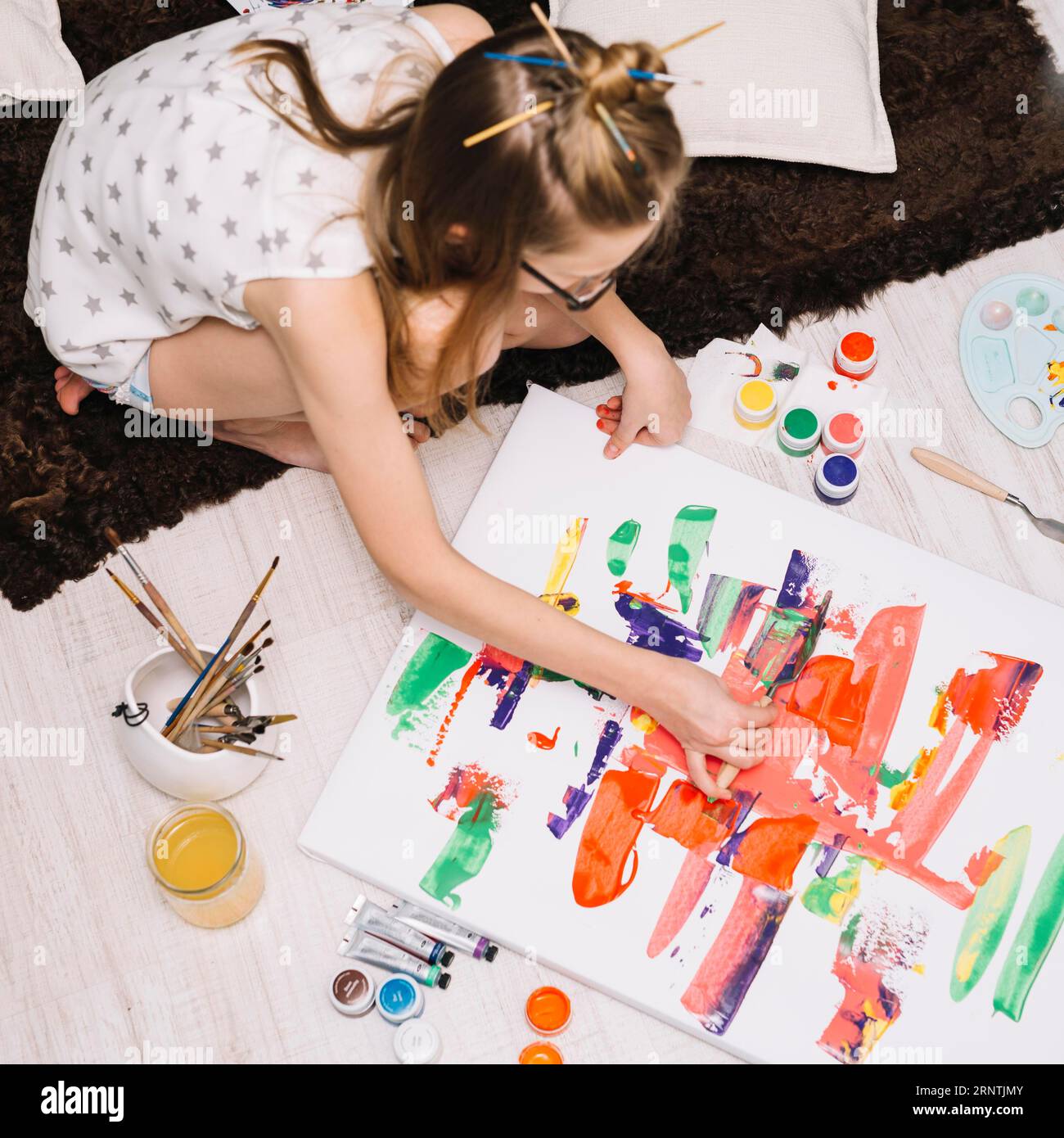Girl painting with bright gouache paper floor Stock Photo - Alamy