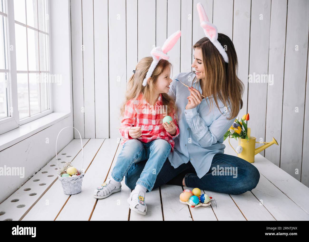 Girl mother having fun while painting eggs easter Stock Photo