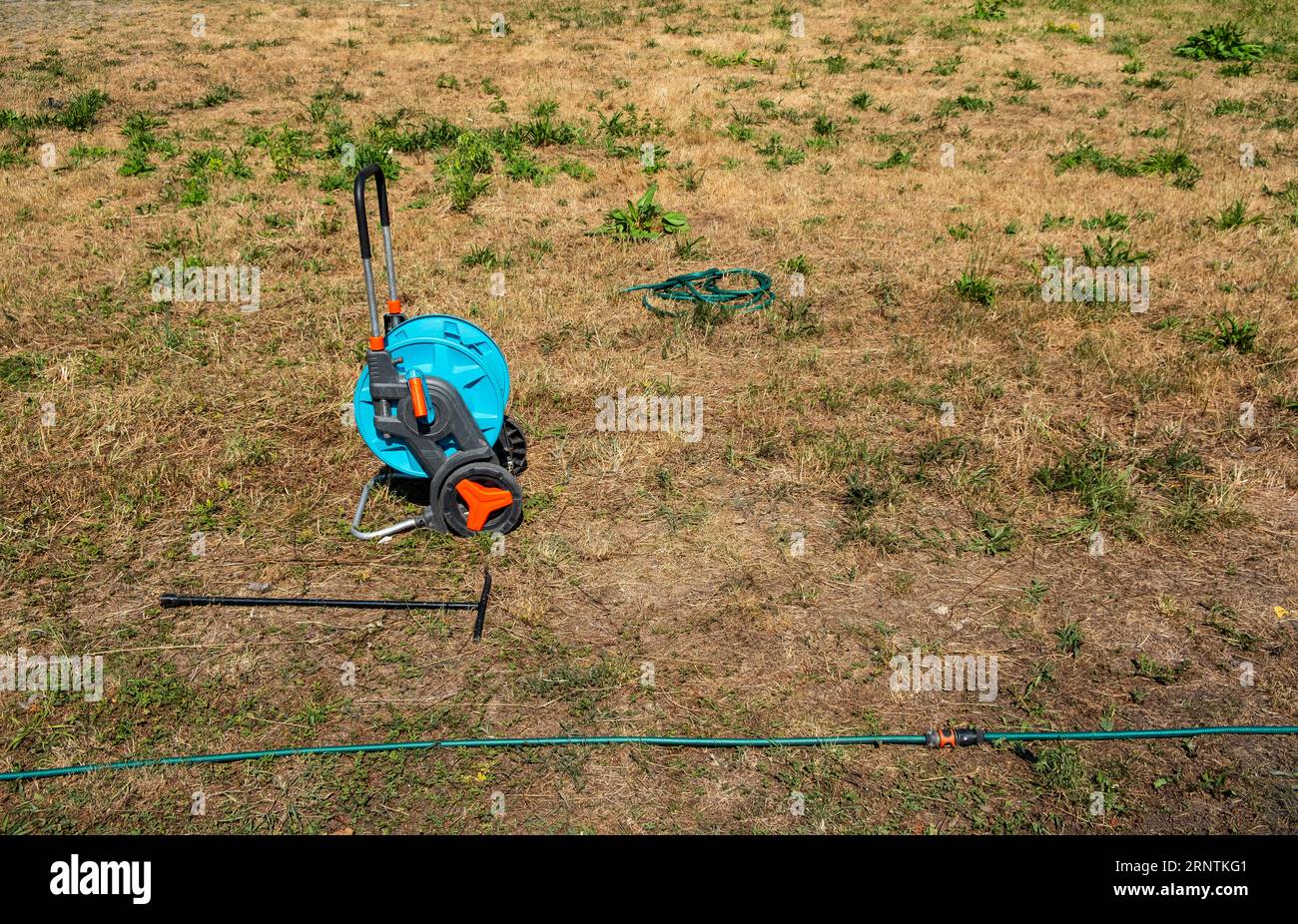 A hose reel stands on a withered meadow, Essen, Germany Stock