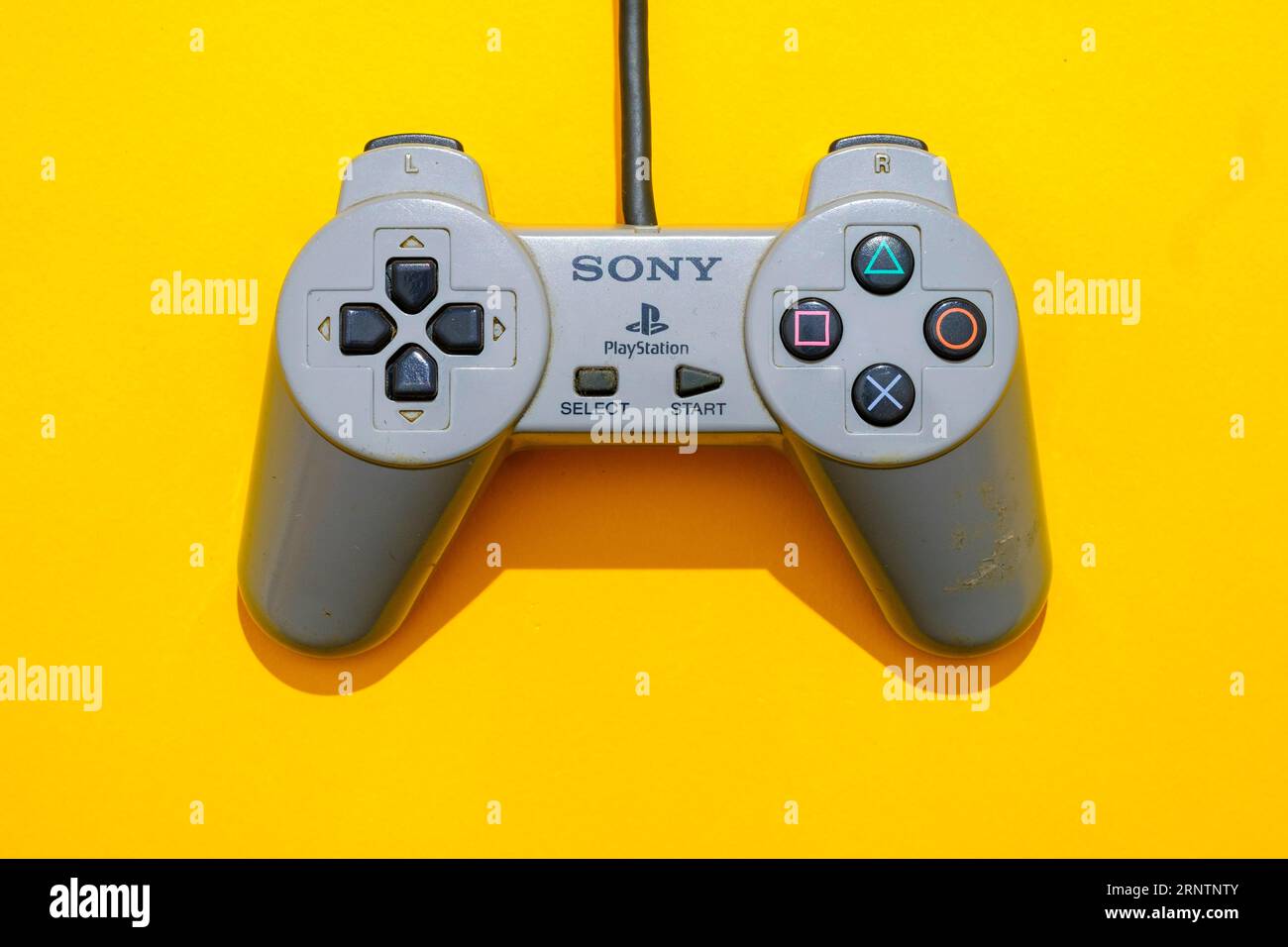 Original Sony Playstation 1 controller, top view against yellow background Stock Photo