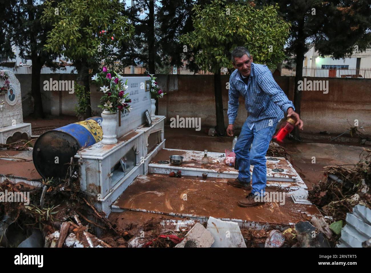 (171117) -- ATHENS, Nov. 17, 2017 -- A man cleans a grave in a damaged cemetery after the flash flooding in Mandra, Greece on Nov. 16, 2017. The strong torrential downpour which turned roads into muddy rivers in the municipalities of Mandra, Nea Peramos and Megara, about 20 kilometers west of the Greek capital, has claimed 16 lives, according to the latest official count. )(swt) GREECE-ATHENS-FLOODING LefterisxPartsalis PUBLICATIONxNOTxINxCHN Stock Photo