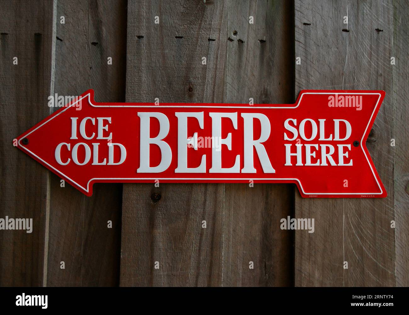 Red arrow with white text reads Ice Cold Beer Sold Here on a wood wall