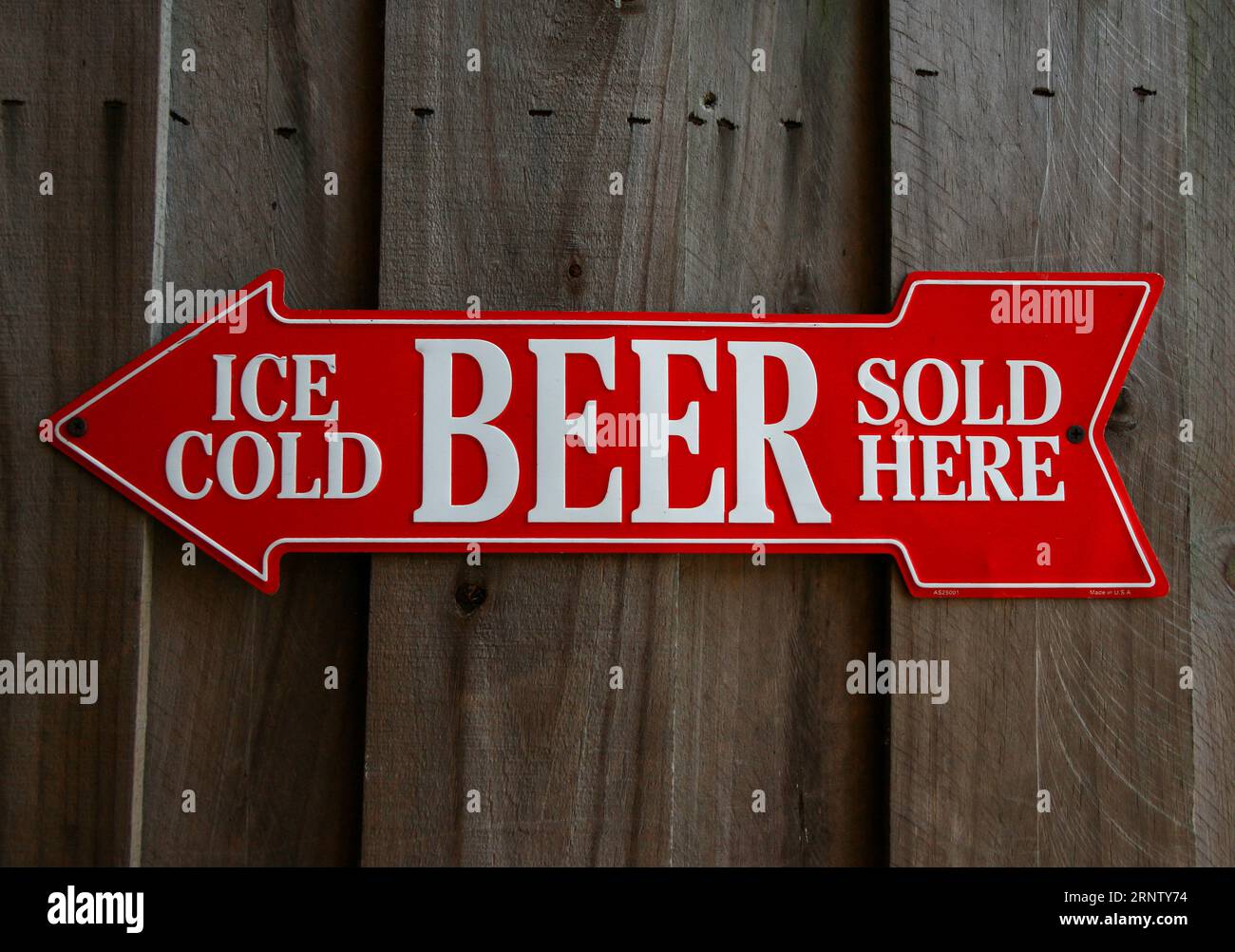 Red arrow with white text reads Ice Cold Beer Sold Here on a wood wall. Stock Photo