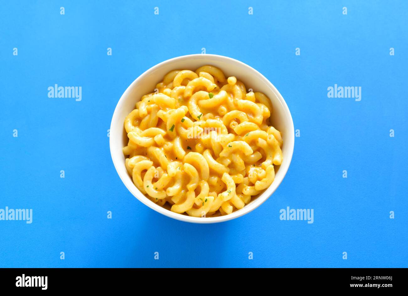 Macaroni and cheese in bowl over blue background. Close up view Stock Photo
