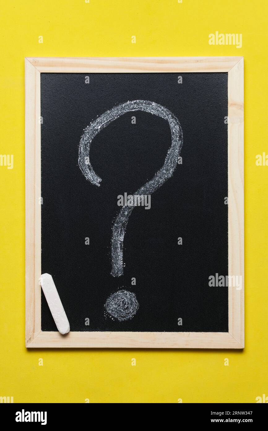 Question mark is drawn in chalk blackboard on yellow background Stock Photo
