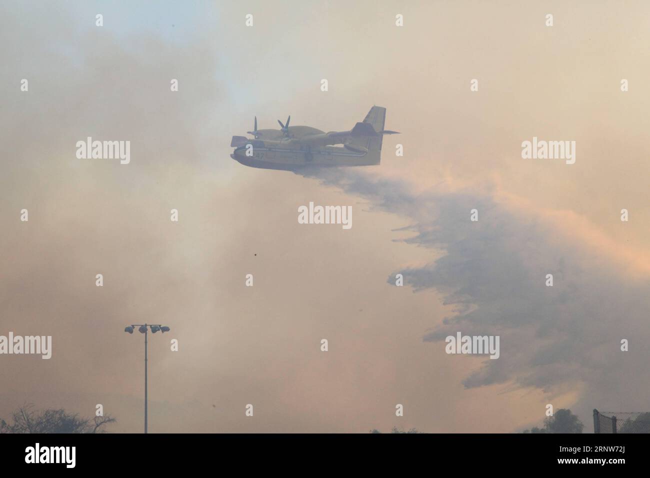 (171206) -- CALIFORNIA, Dec. 6, 2017 -- A plane drops water in Ventura County of California, the United States, Dec. 5, 2017. Brush fires across the region were fed by extremely high winds, low humidities and dry fuel. Hundreds of fire fighters have been working very hard to minimize damage to property and evacuations are taking place in many places in south California, said authorities. ) (zjy) U.S.-CALIFORNIA-WILDFIRE HuangxHeng PUBLICATIONxNOTxINxCHN Stock Photo