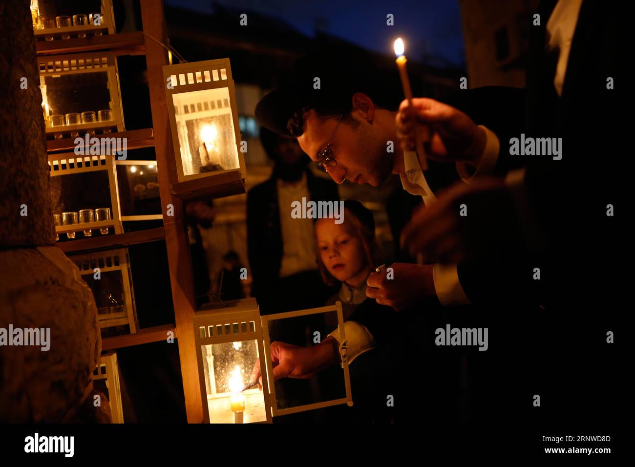 (171214) -- JERUSALEM, Dec. 14, 2017 -- An ultra-Orthodox Jewish man lights a candle during Hanukkah in Mea Shearim neighborhood in Jerusalem, on Dec. 14, 2017. Hanukkah, also known as the Festival of Lights and Feast of Dedication, is an eight-day Jewish holiday commemorating the rededication of the Holy Temple (the Second Temple) in Jerusalem at the time of the Maccabean Revolt against the Seleucid Empire of the 2nd Century B.C. ) MIDEAST-JERUSALEM-HANUKKAH GilxCohenxMagen PUBLICATIONxNOTxINxCHN Stock Photo