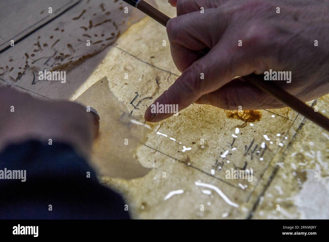 (171222) -- CHENGDU, Dec. 22, 2017 -- Yuan Dongjue repairs one page of a book over 180 years, in Sichuan Provincial Library in Chengdu, capital of southwest China s Sichuan Province, Dec. 21, 2017. Yuan Dongjue, a 70-year-old expert of ancient books repairs, has kept working on ancient book repair and conservation since 1983 in Ancient Books Repair Center of Sichuan Provincial Library. In her 34 years career time, Yuan has repaired about 200 valuable ancient Chinese books, some of them could date back to 1,000 years ago. The repair work consists of over 10 different steps. To repair only one p Stock Photo