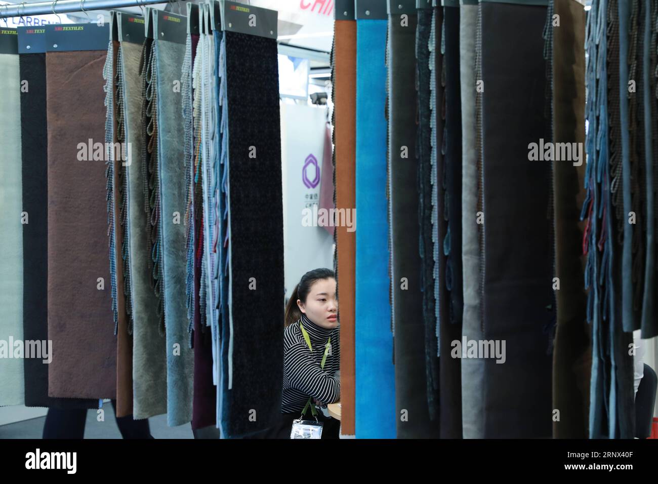 (180112) -- FRANKFURT, Jan. 12, 2018 -- A worker sits at a Chinese textile booth at Heimtextil, the world s largest international trade fair for home and contract textiles, in Frankfurt, Germany, on Jan. 11, 2018. A total of 2,975 exhibitors from 64 countries and regions attended the trade fair this year, 545 of which are from China. ) (djj) GERMANY-FRANKFURT-HEIMTEXTIL-CHINA LuoxHuanhuan PUBLICATIONxNOTxINxCHN Stock Photo