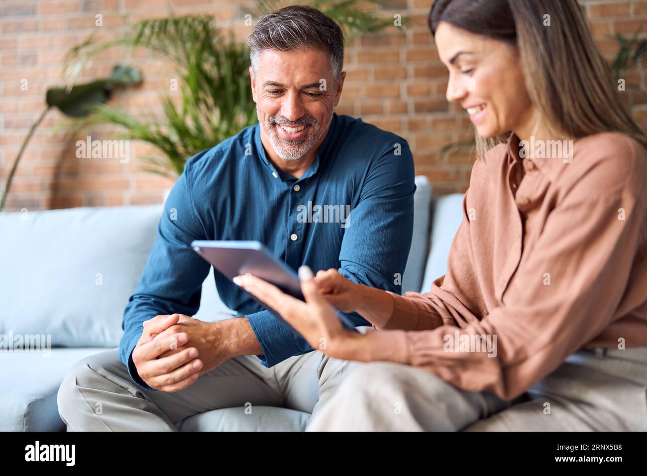 Two happy professional business executives using tablet in office. Stock Photo