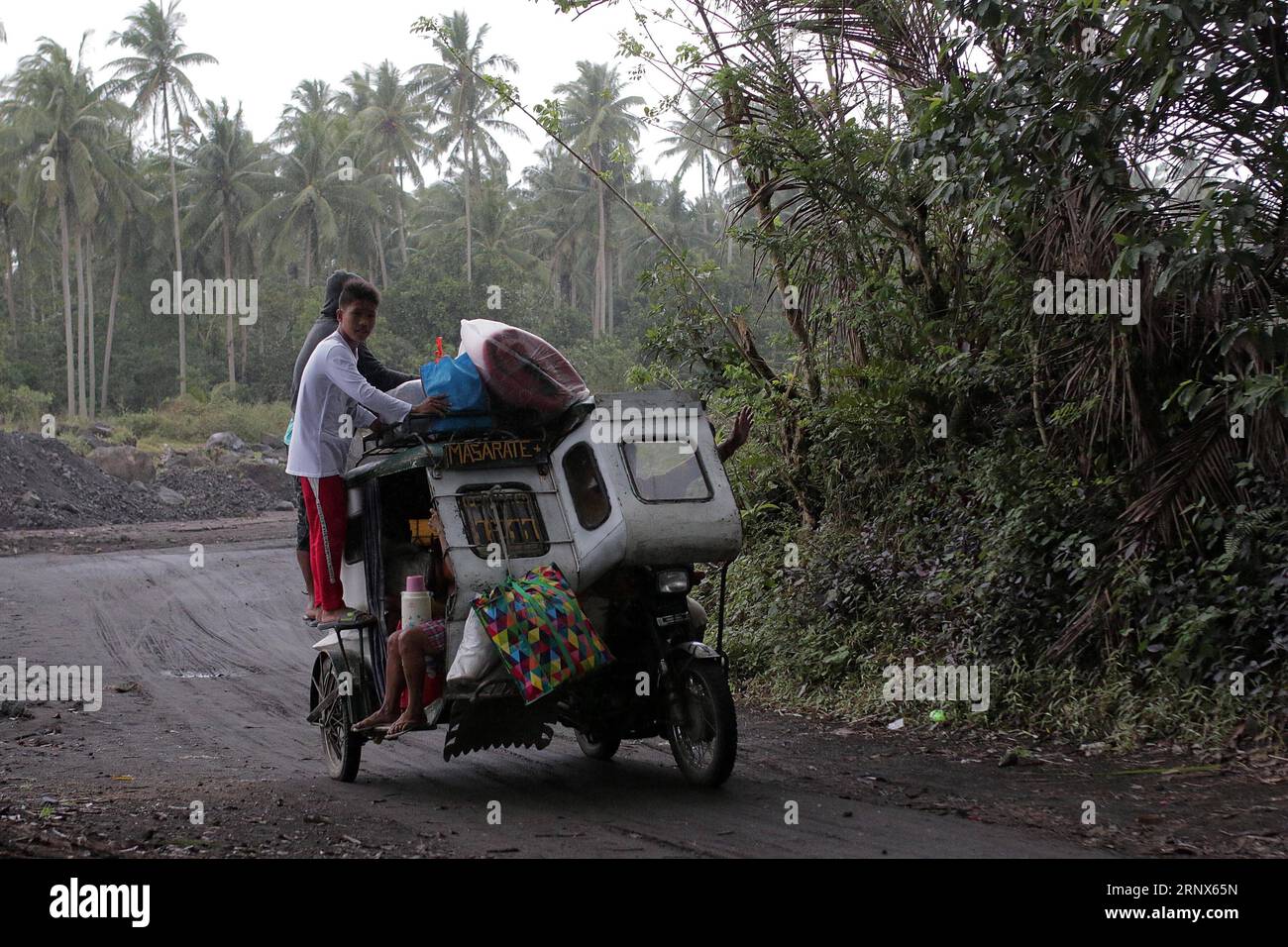 (180114) -- ALBAY, Jan. 14, 2018 () -- Residents flee with belongings on board a tricycle as they move to an evacuation center in Albay Province, the Philippines, Jan. 14, 2018. Nearly a thousand families living close to the Mayon Volcano evacuated from their homes as Philippine authorities raised its alert level of the Mayon volcano on Sunday for the second time in less than 24 hours from increasing unrest to increased tendency towards eruption within weeks or even days. (/Stringer) (zjy) THE PHILIPPINES-ALBAY-VOLCANO-ALERT Xinhua PUBLICATIONxNOTxINxCHN Stock Photo