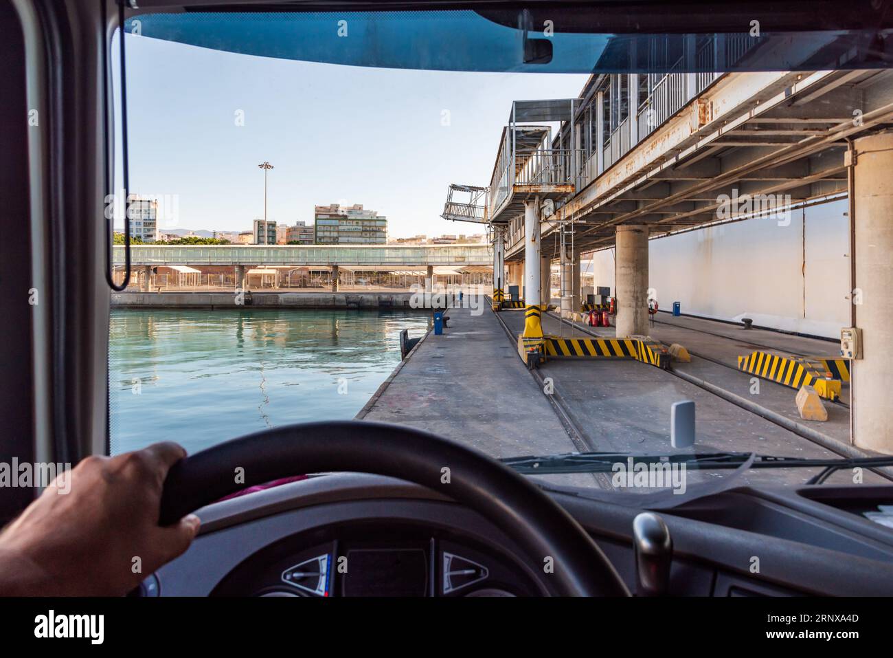 Truck leaving a dock in the port with the complications of the narrowness of the place. Stock Photo