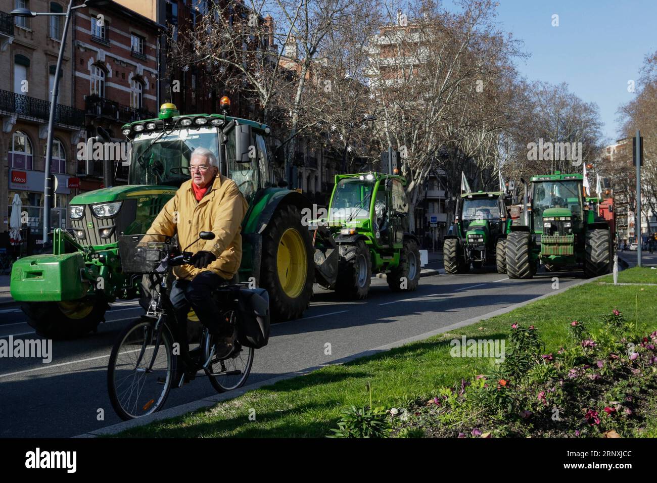 (180201) -- TOULOUSE, Feb. 1, 2018 -- A cyclist passes by the tractors in demonstration in Toulouse, France, Jan. 31, 2018. Farmers set up a filter dam on Wednesday to slow down traffic to protest against the decrease of the subsidies allocated in the region. ) (gj) FRANCE-TOULOUSE-FARMERS-DEMONSTRATION JosexSantos PUBLICATIONxNOTxINxCHN Stock Photo