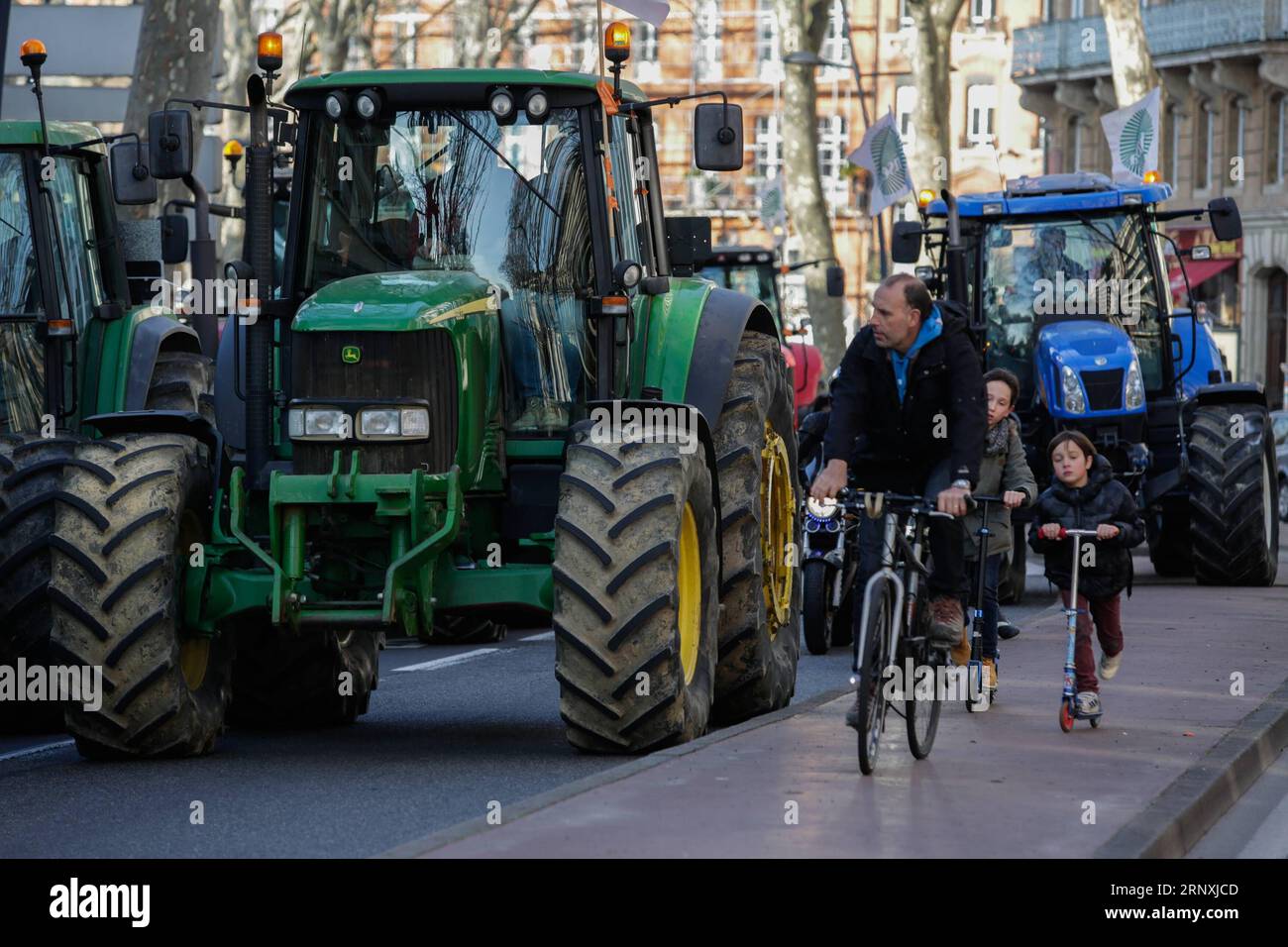 (180201) -- TOULOUSE, Feb. 1, 2018 -- Cyclists pass by the tractors in demonstration in Toulouse, France, Jan. 31, 2018. Farmers set up a filter dam on Wednesday to slow down traffic to protest against the decrease of the subsidies allocated in the region. ) (gj) FRANCE-TOULOUSE-FARMERS-DEMONSTRATION JosexSantos PUBLICATIONxNOTxINxCHN Stock Photo