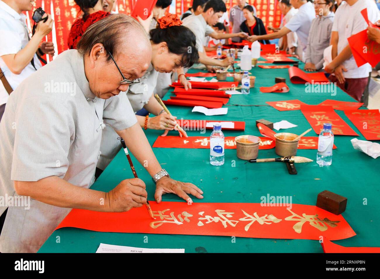 (180208) -- HO CHI MINH CITY, Feb. 8, 2018 -- Calligraphers write new year couplets at a charity event to celebrate the Lunar New Year in Ho Chi Minh city, Vietnam, Feb. 8, 2018. )(rh) VIETNAM-HO CHI MINH CITY-CHINESE LUNAR NEW YEAR-CALLIGRAPHY EVENT HoangxThixHuong PUBLICATIONxNOTxINxCHN Stock Photo