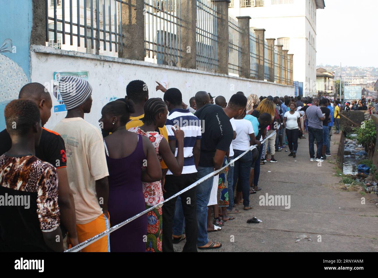 (180307) -- FREETOWN, March 7, 2018 -- Voters wait in line outside a polling station in Freetown, Sierra Leone, on March 7, 2018. More than 3.1 million registered voters in Sierra Leone on Wednesday are to hit the polling stations across the country to elect a new president. ) (zf) SIERRA LEONE-FREETOWN-POLITICS-GENERAL ELECTION KerifallahxJanneh PUBLICATIONxNOTxINxCHN Stock Photo