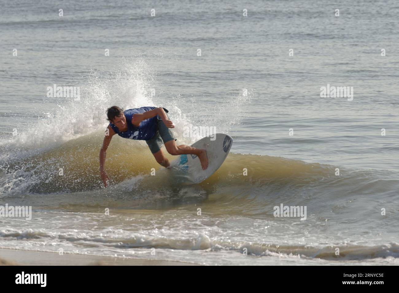 Male contestant rides for points during heat at the Zap Pro/Am Championships of Skimboarding, August 11, 2023, Dewey Beach, Delaware USA. Stock Photo