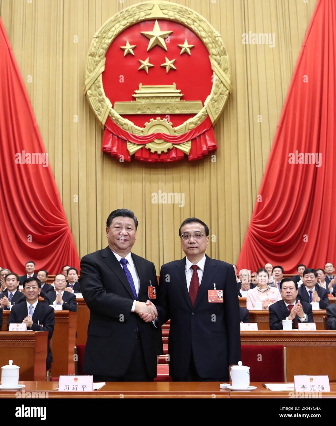Bilder des Tages (180318) -- BEIJING, March 18, 2018 -- Xi Jinping (L, front) shakes hands with Li Keqiang at the sixth plenary meeting of the first session of the 13th National People s Congress (NPC) at the Great Hall of the People in Beijing, capital of China, March 18, 2018. Li Keqiang was endorsed as Chinese premier Sunday at the ongoing first session of the 13th NPC, the country s national legislature. Nearly 3,000 NPC deputies voted to approve the premiership nomination of Li, by newly-elected President Xi Jinping. ) (TWO SESSIONS)CHINA-BEIJING-XI JINPING-LI KEQIANG-NPC-SIXTH PLENARY ME Stock Photo