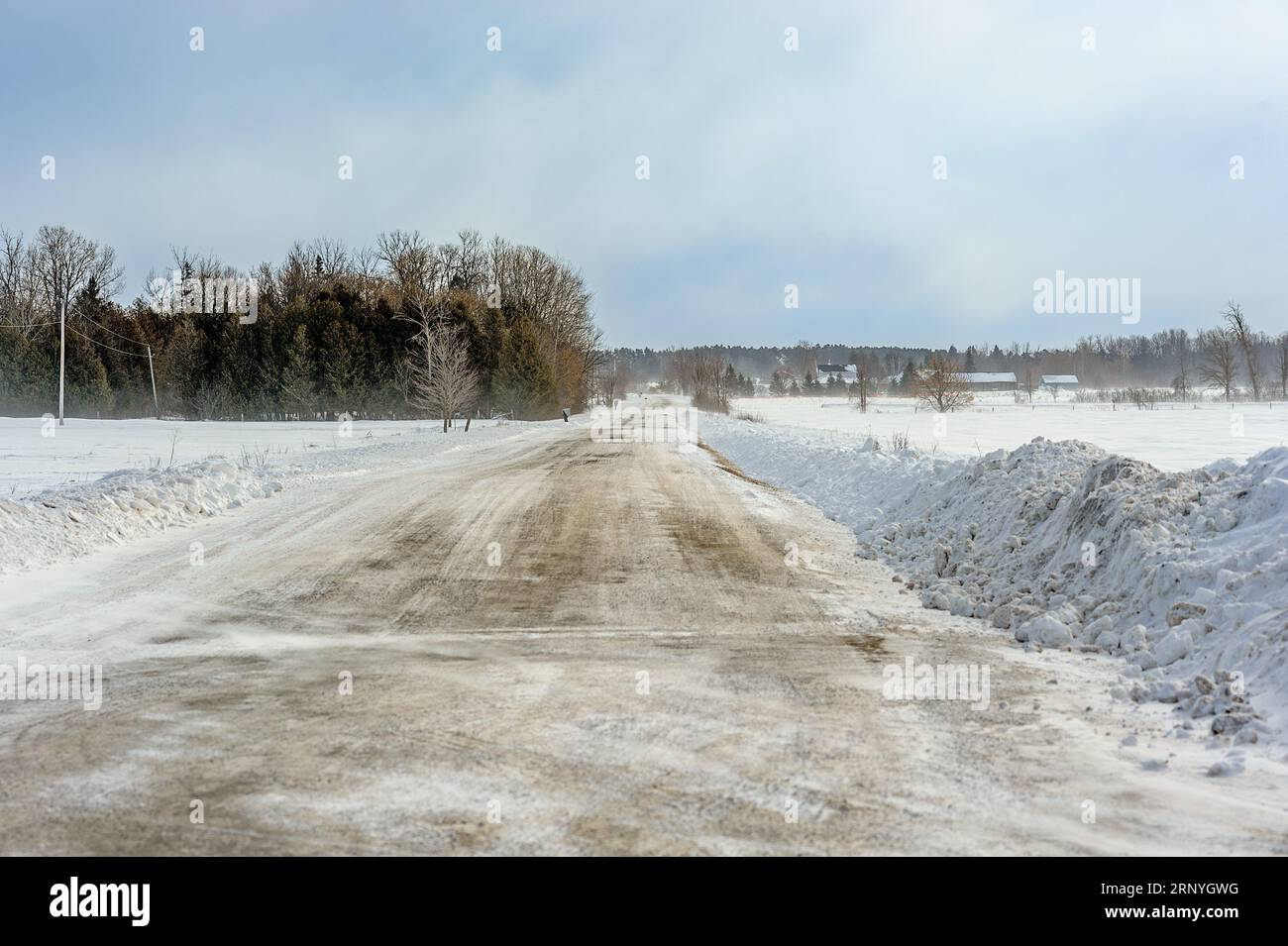 gravel road has been plowed after the snow storm Stock Photo