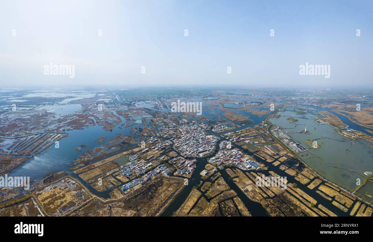 (180401) -- XIONGAN NEW AREA, April 1, 2018 -- This aerial photo taken on March 29, 2018 shows a village amid the Baiyangdian lake in Xiongan New Area, north China s Hebei Province. Xiongan New Area, established on April 1, 2017, is a new economic zone about 100 kilometers southwest of Beijing. It is the third new area of national significance after the Shenzhen Special Economic Zone and the Shanghai Pudong New Area. China aims to build it as a low-carbon, intelligent, livable and globally influential city where people and nature exist in harmony. ) (lmm) CHINA-XIONGAN NEW AREA-ANNIVERSARY-AER Stock Photo