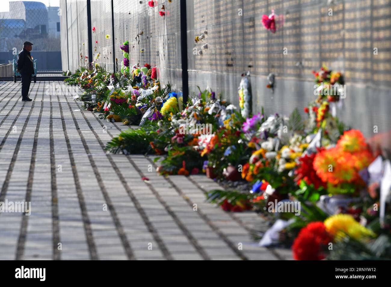 (180404) -- TANGSHAN, April 4, 2018 -- Flower are laid in front of a memorial wall in remembrance of victims in the 1976 Tangshan Earthquake in Tangshan, north China s Hebei Province, April 4, 2018, one day before the Qingming Festival when the deceased are commemorated.) (lmm) CHINA-HEBEI-EARTHQUAKE-VICTIM-REMEMBRANCE (CN) DongxJun PUBLICATIONxNOTxINxCHN Stock Photo