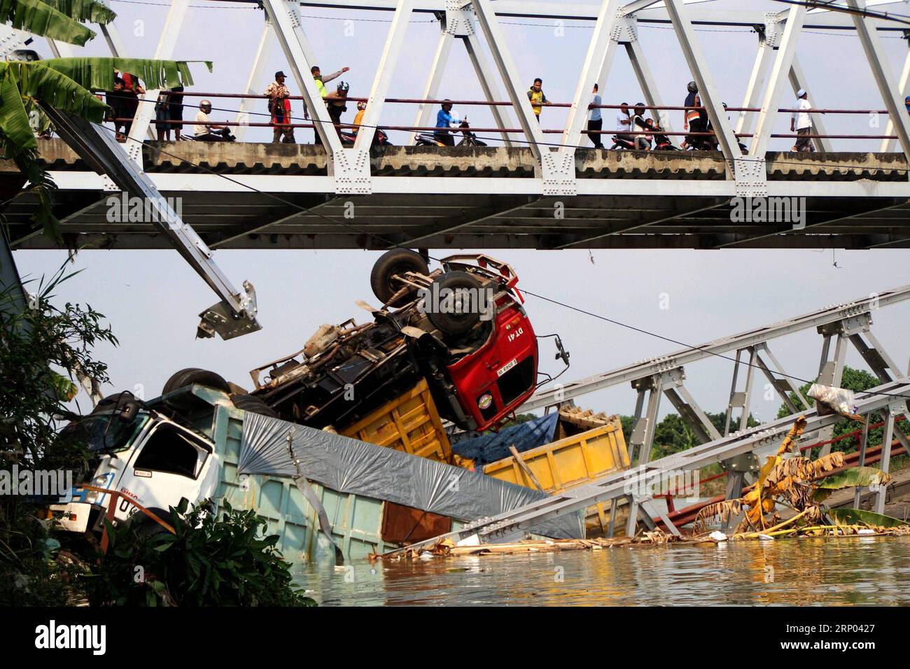 Themen der Woche KW16 Bilder des Tages (180417) -- TUBAN, April 17, 2018 -- People watch three trucks and one motorcycle which plunged into the river when the bridge collapsed in Tuban, East Java province, Indonesia, April 17, 2018. Rescuers discovered two corpses of truck drivers and are searching for other missing people after a bridge fell down in East Java province of Indonesia on Tuesday, a disaster agency official disclosed. ) (lrz) INDONESIA-TUBAN-BRIDGE COLLAPSE Kurniawan PUBLICATIONxNOTxINxCHN Stock Photo