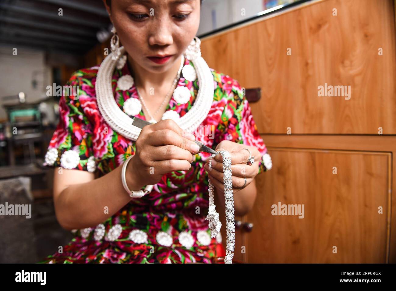 (180523) -- KAILI, May 23, 2018 -- Yang Changlan processes silverwork in Hongxi Village in Wanshui Township of Kaili, southwest China s Guizhou Province, May 22, 2018. The 36-year-old Yang Changlan has engaged in silverwork making for 12 years. In 2017, Yang and her husband founded a silverwork cooperative and helped other villagers to increase income. )(mcg) CHINA-GUIZHOU-KAILI-SILVERSMITH (CN) TaoxLiang PUBLICATIONxNOTxINxCHN Stock Photo
